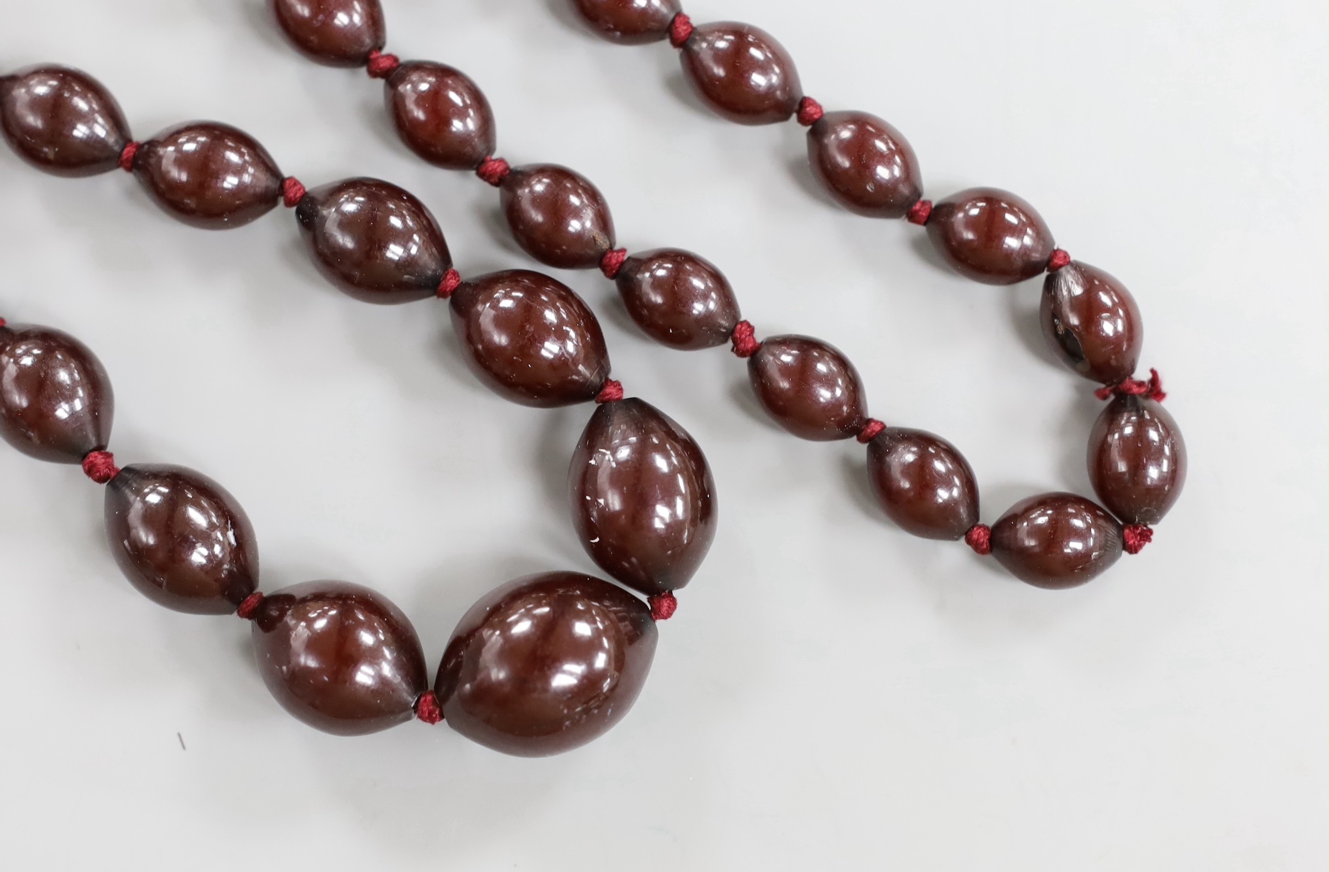 A single strand graduated oval simulated cherry amber bead necklace, 94cm, gross weight 100 grams.